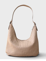 A woven leather hobo shoulder bag in a light tan/cream color, featuring a single shoulder strap and a zippered top closure, set against a plain light gray background.