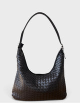 A black woven leather hobo shoulder bag with a single shoulder strap, photographed against a light gray studio background.