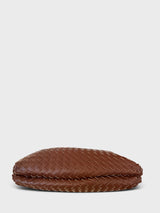 A brown woven leather shoulder bag with a single strap and gold-tone hardware, shown from the base profile view against a light gray background.