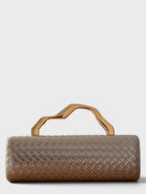 Vegan leather woven-embossed clutch in pewter with sculptural gold top handle. 